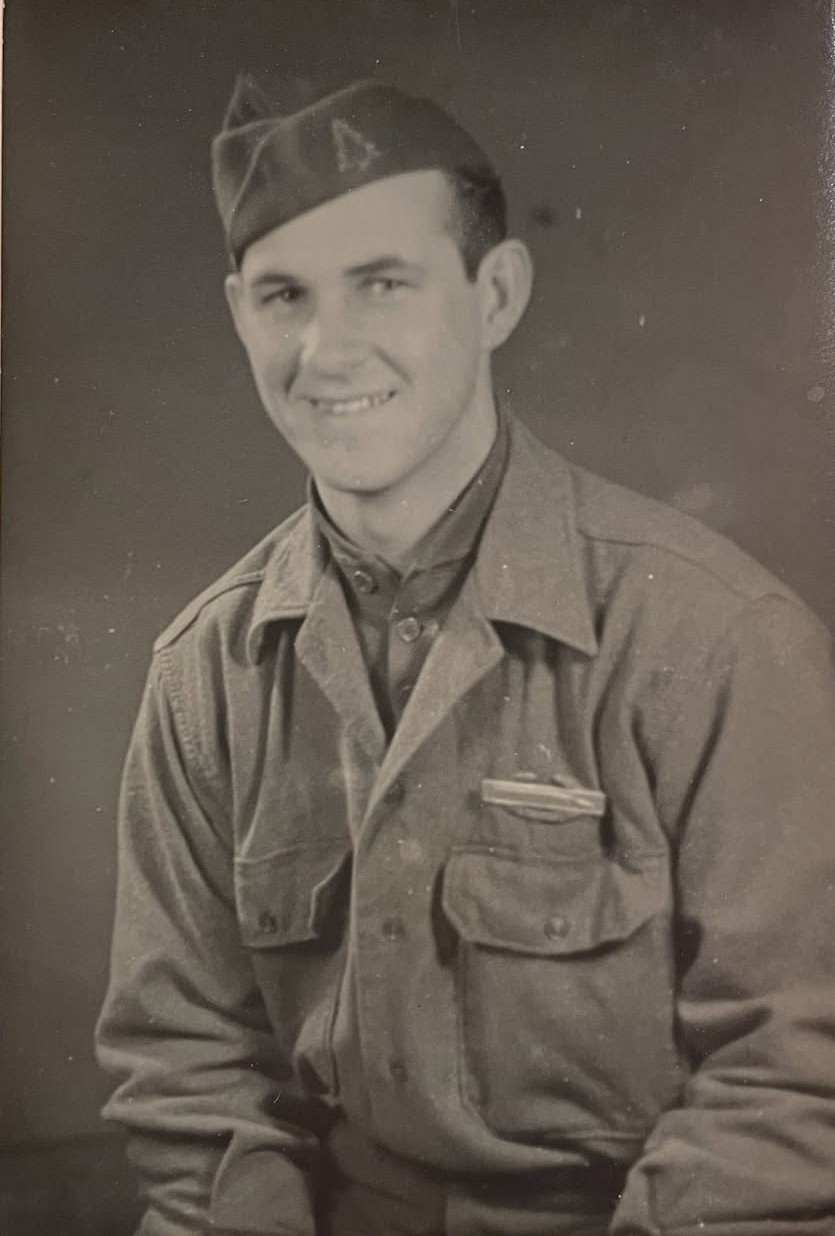 Studio portrait of Lyle E. Austin in uniform, wearing a garrison cap and a ribbon bar above his left pocket